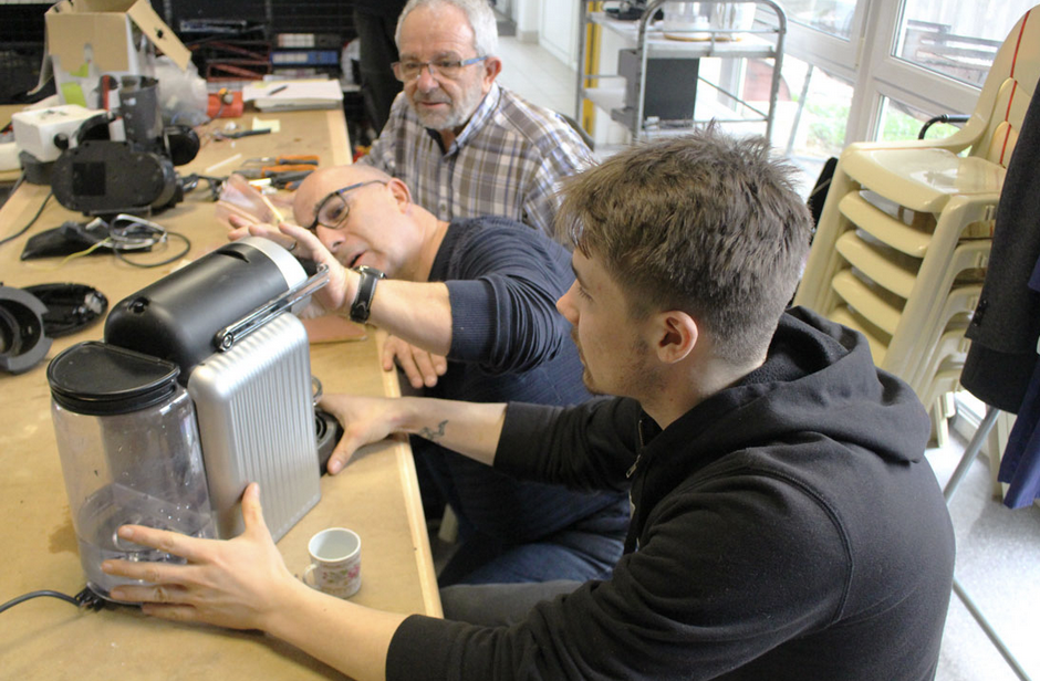 Deux personnes réparent une cafetière lors d'un repair café