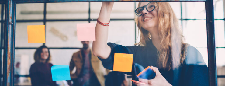 Etudiante collant un post it sur tableau