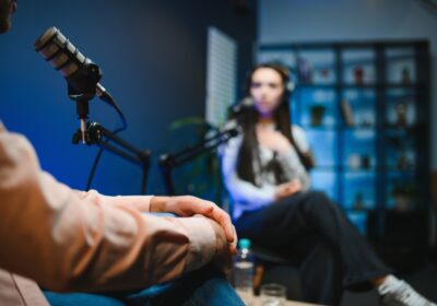 Un homme et une femme en pleine interview dans un studio radio/podcast