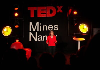 Femme sur scène s'adreessant au publioc lors du Tedxminesnancy