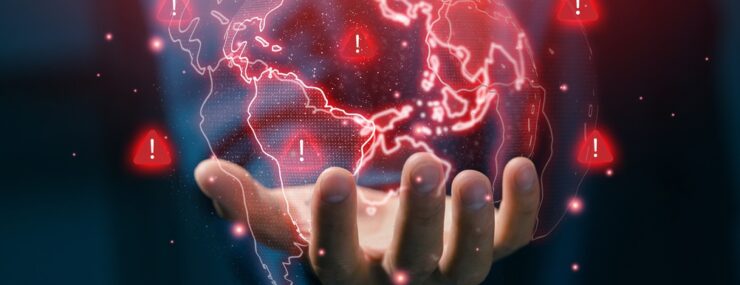 Concept d'alerte mondiale sur les risques et les crises avec main d'oeuvre tenant une carte numérique du monde, montrant les signaux d'alerte, les menaces mondiales et la gestion des risques dans un environnement commercial international.