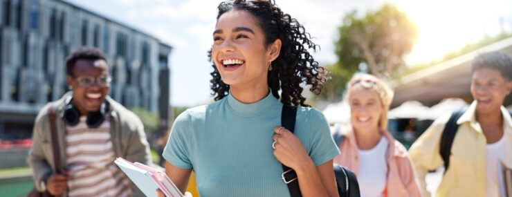 Marcher, heureux et fille avec des amis à l'université pour apprendre, se lier et parler avec plaisir. Personnes, école et groupe d'étudiants de la gén z qui font des trajets en plein air prêts pour l'éducation sur le campus universitaire.